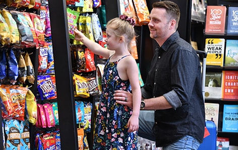The Des Moines International Airport offers several services and amenities. Father and daughter buying snacks at the Des Moines International Airport